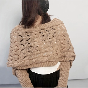 Detail of camel knitted shawl featuring hollow-out patterns and ribbed hem on the back
