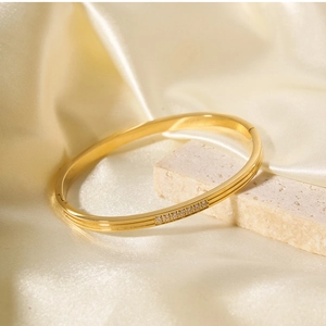 Detailed view of an 18k gold plated stainless steel bracelet with seven inlaid zircons