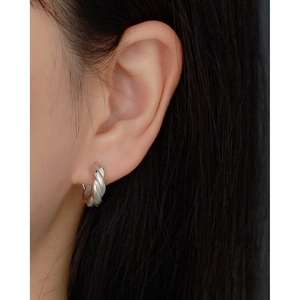 Close-up of S925 sterling silver twisted hoop earrings worn by a model for a chic look