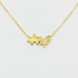 Close-up of a 14K gold plated S925 silver jigsaw necklace with cubic zirconia pendant