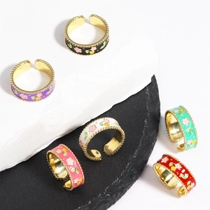 Macro shot of colorful enamel flower rings displayed on elegant stone pedestals