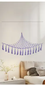 Detail of purple woven macrame toy hammock with cotton tassels and wooden beads decor