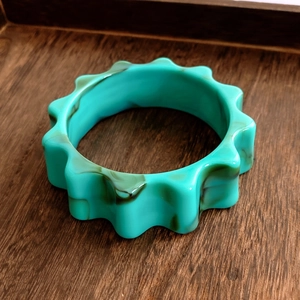 Détail du bracelet en résine turquoise avec bords festonnés et texture marbrée chic