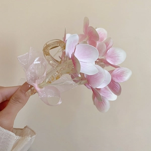 Pink and white fabric flower hair claw clip with mesh bow accessory for women