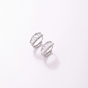 Détail de boucles d'oreilles huggie en argent avec zircone baguette et sertissage à griffes