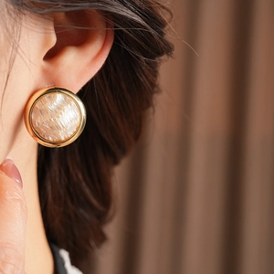 Vue détaillée de boucles d'oreilles cœur plaquées or 16K avec perle sur l'oreille