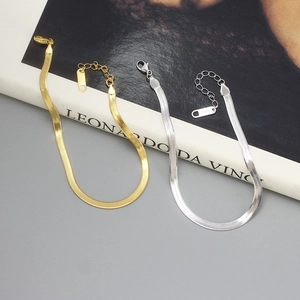 Detailed macro view of S925 sterling silver flat snake chain bracelets in gold and silver