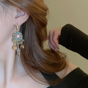 Detail of vintage flower drop earrings with crystals worn by model for elegant style