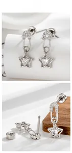 Safety pin earring with star pendant and heart cubic zirconia on a minimalist white stand
