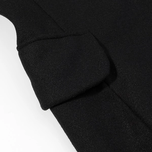 Gros plan d'une poche à rabat sur un manteau en laine noir montrant la texture du tissu