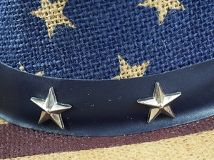 Détail de chapeau western avec étoiles en toile, ruban cuir et clous en étoile