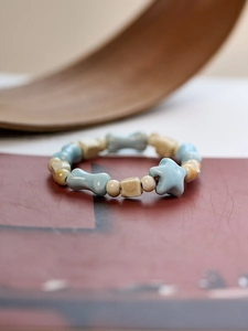 Detailed shot of handmade ceramic bracelet with blue and beige star and bone beads