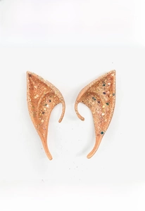 Close-up of glittery elf ears with gold and colorful sequins for Halloween cosplay
