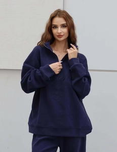 Détail d'un sweat bleu marine à demi-zip avec lettrage embossé et fermeture éclair en métal