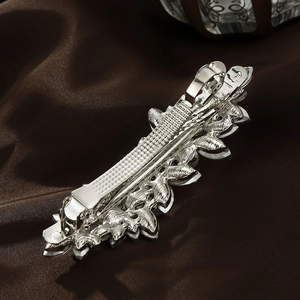 Detailed back view of silver spring clip showing secure metal mechanical clasp and rhinestones