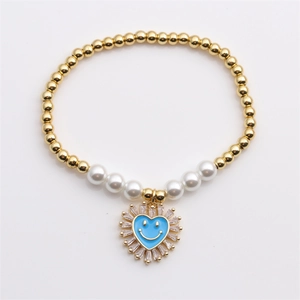 Bracciale di perle dorate con ciondolo a cuore blu sorridente e zirconi bianchi lucidi