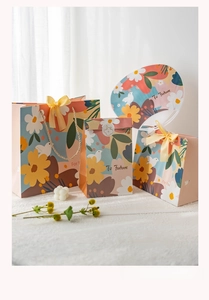 Detail of floral gift bags with yellow silk bows and matching paper fans set