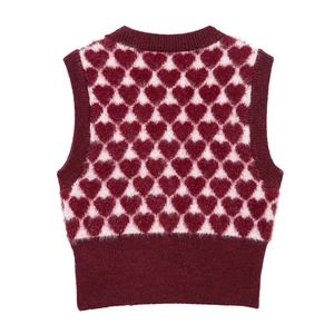 Détail du motif à cœurs et de l'encolure côtelée bordeaux sur le gilet en tricot