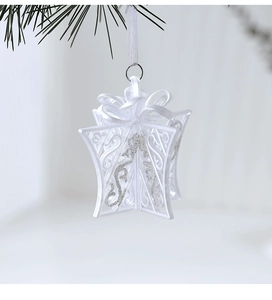 Close-up of white glitter gift box Christmas ornament with intricate hollowed-out details