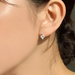 Close-up of model wearing 925 silver stud earrings with rhombus zircon stones