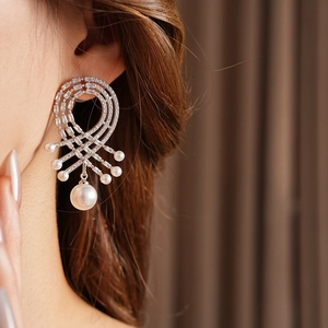 Gros plan de boucles d'oreilles rétro en argent avec perles et zircons sur mannequin
