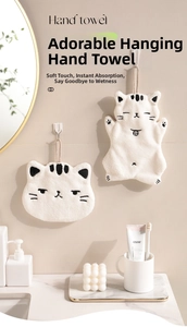 Detail showing plush coral fleece cat-shaped hand towels with hanging loops on bathroom wall