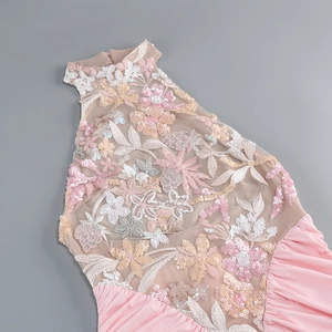 Dettaglio di abito in rete rosa con squisiti ricami floreali multicolori e paillettes