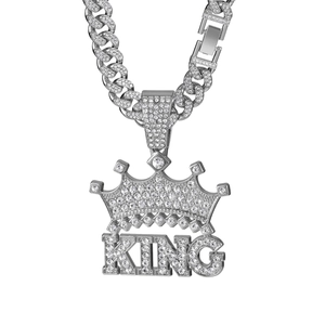 Detail of silver Cuban chain necklace with iced-out KING crown pendant and crystals