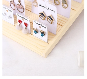 Detail of wooden earring display stand with pine wood base for jewelry organization