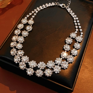 Close-up of a silver double-layered floral necklace with sparkling zircon on a black display box