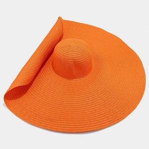 Macro detail of wide-brimmed straw hat in bright orange with fine woven texture