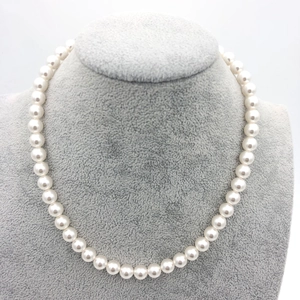 Detailed view of high-lustre white round pearl necklace displayed on a jewelry bust