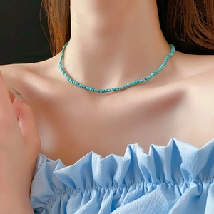 Gros plan d'un collier bohème en perles de turquoise avec petites pierres bleu-vert