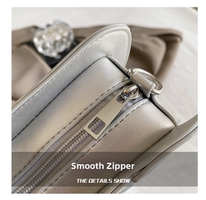 Macro shot of smooth silver metal zipper on lychee pattern PU leather handbag