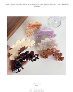 Macro view of large acetate floral hair claw clips with marble texture in various colors