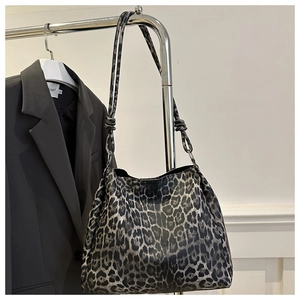 Detail of leopard print tote bag with thin straps styled on a metal stand with a blazer