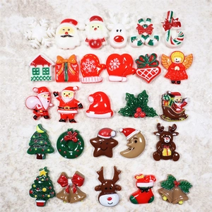 Diverse Weihnachts-Harzanhänger wie Weihnachtsmann und Rentiere auf Marmorhintergrund