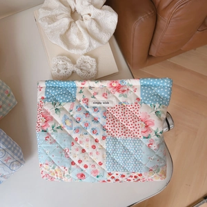 Detailed close-up of a quilted floral makeup bag with simple wish label on cotton fabric