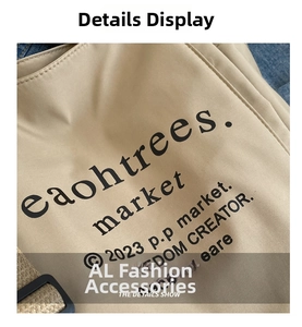 Close-up of beige canvas tote bag showing textile texture and black graphic print details