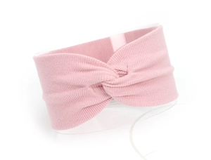 Close-up of pink ribbed knit baby headband with a cross knot design on a round stand