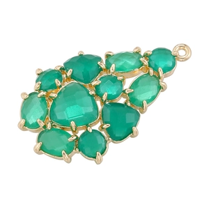 Detail of a pear-shaped copper pendant with green gemstones in a gold finish