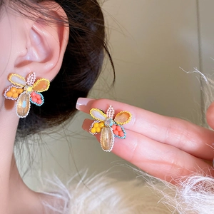 Macro detail of colorful crystal flower earrings with intricate beadwork and silver pins