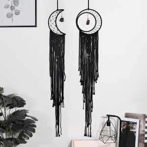 Set of two black cotton woven moon and round dreamcatchers with long tassels on a wall
