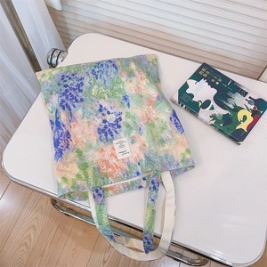 Macro view of floral oil painting canvas tote bag with white square brand label