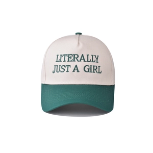 Close-up of embroidered 'LITERALLY JUST A GIRL' slogan on cotton baseball cap texture
