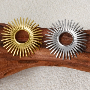 304 stainless steel sunburst stud earrings in gold and silver on a wooden block