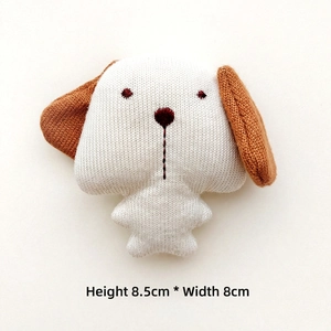 Detail view of a handmade knit dog charm with dimensions 8.5cm height and 8cm width