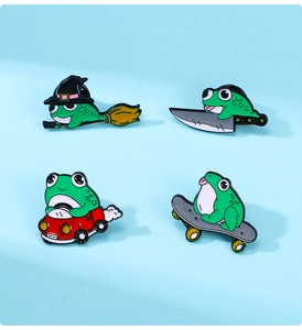 Detailed view of four enamel frog pins including a frog riding a broom and skateboarding