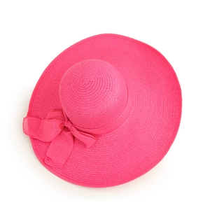 Detail of a bright fuchsia wide-brim sun hat featuring an elegant woven bow accent