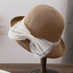 Chapeau cloche en paille marron avec ruban en dentelle à pois et un grand nœud